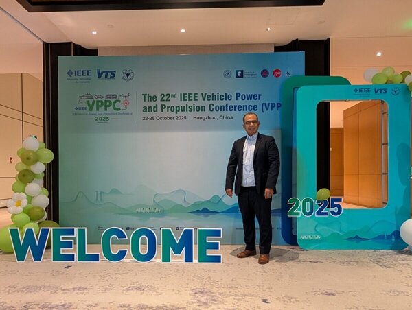 Tedjani Mesbahi devant le panneau de bienvenue de la conférence IEEE VPPC 2025 à Hangzhou en Chine